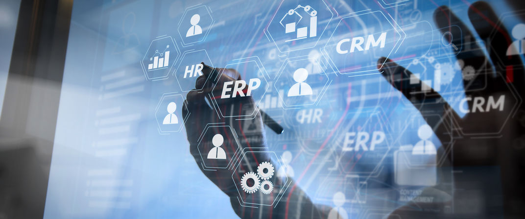 ERP-CRM Une main écrit sur un écran transparent les secteurs gérés par un ERP-CRM.